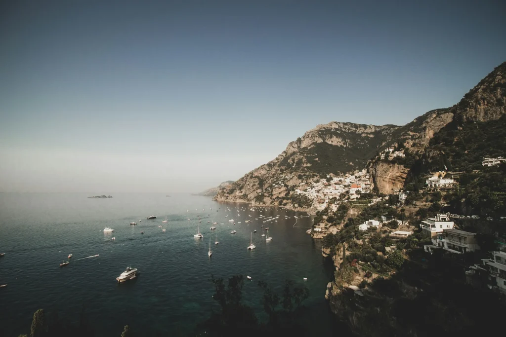 The headland of the Sorrento Peninsula in the morning haze with boats below