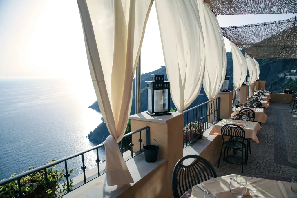A terrace set for dinner on the hillside above the coast