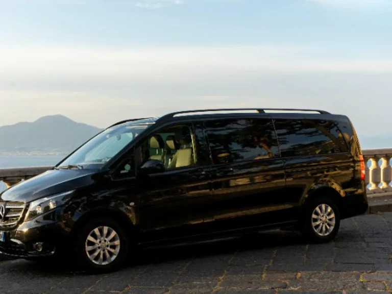 The company black Mercedes minivan parked above the Gulf of Naples with Vesuvius behind