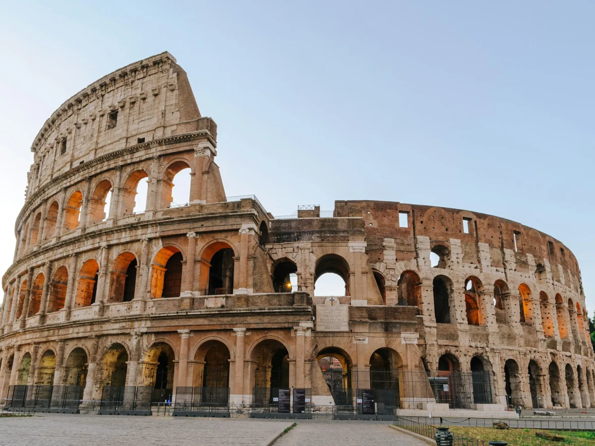 The Colosseum in Rome at golden hour under a clear sky